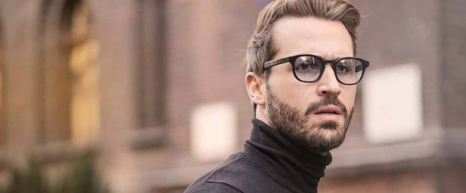 Gepflegter, aber gestresst wirkender Mann mit Brille, der womöglich am Burnout-Syndrom erkrankt ist.
